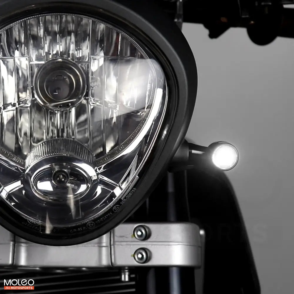 Bullet Front 2 in 1 LED Turn Signals Are Mounted on Vintage Motorcycle, Emitting White Running Light.