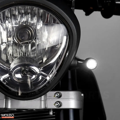 Bullet Front 2 in 1 LED Turn Signals Are Mounted on Vintage Motorcycle, Emitting White Running Light.